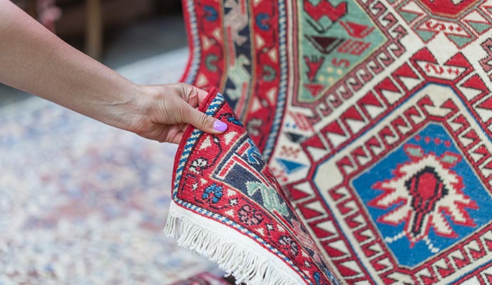 A person inspecting an area rug