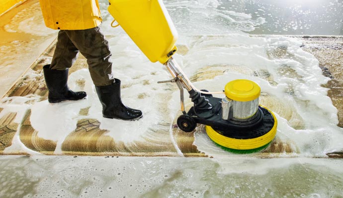 Professional cleaning a rug using equipment