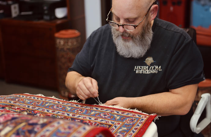 A person is repairing a rug.