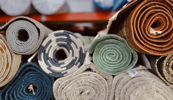 Various rolled-up rugs stored in a shelf